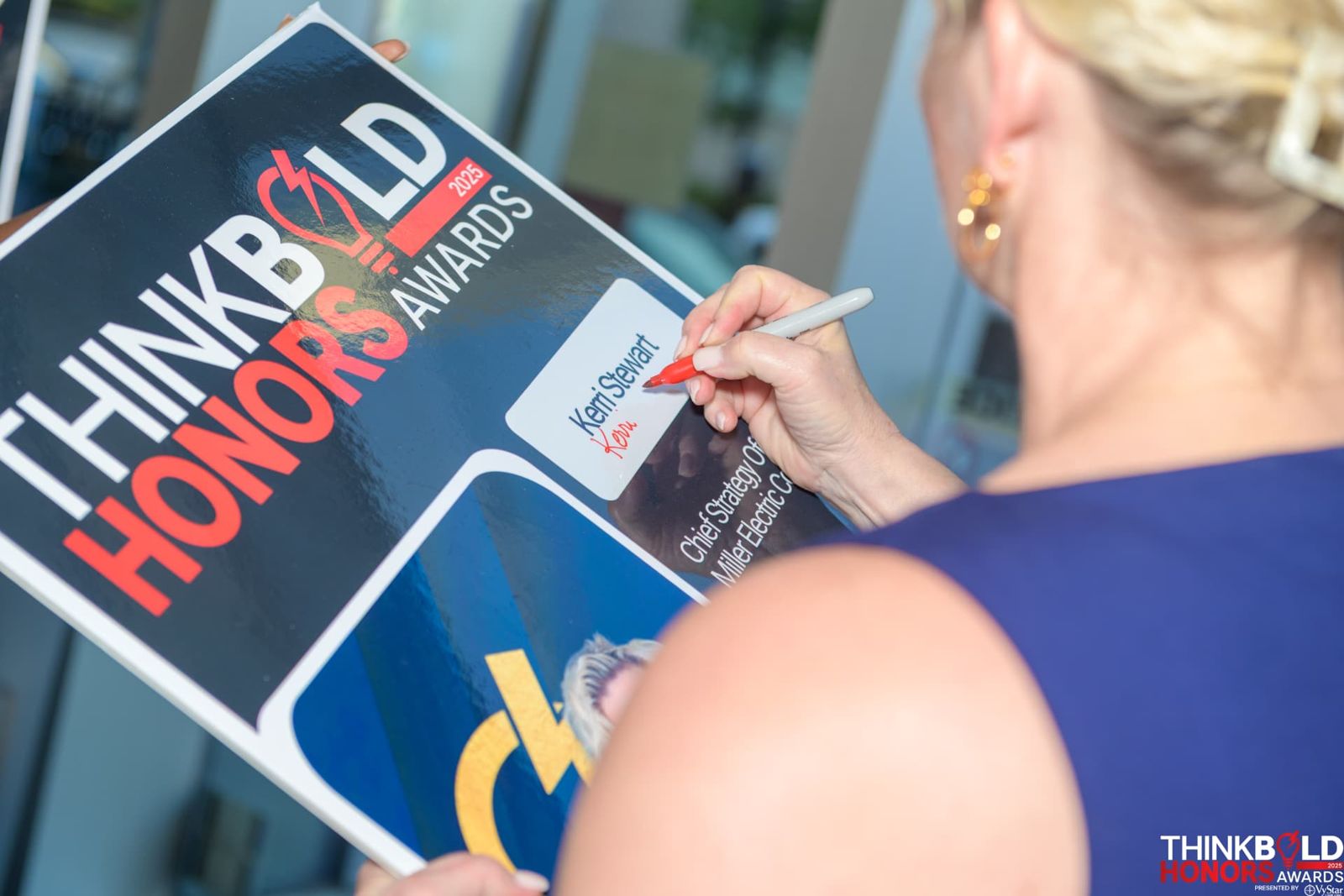 An honoree signing her commemorative Think Bold Honors poster